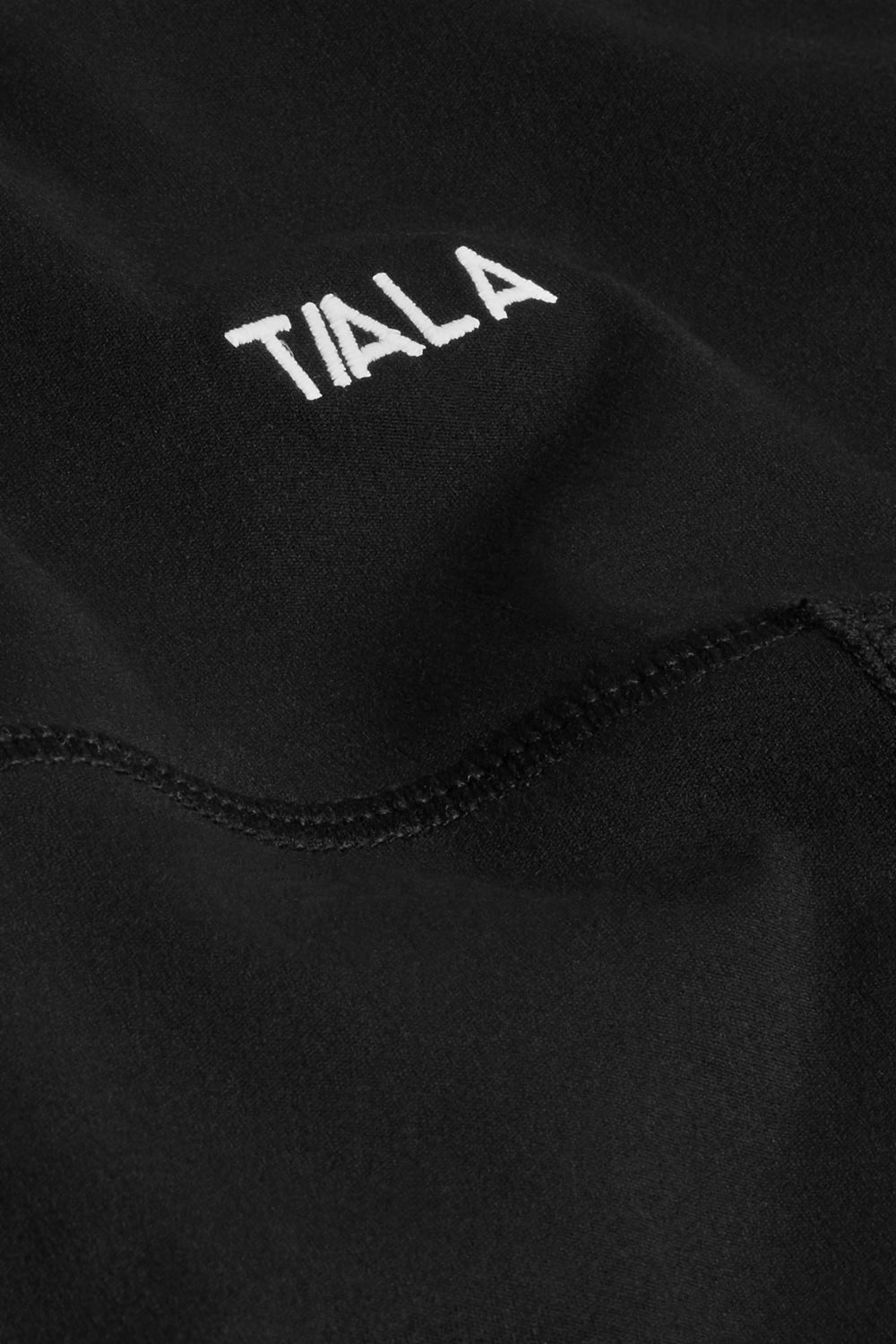 Black capri legging close up of fabric and white TALA embroidered 